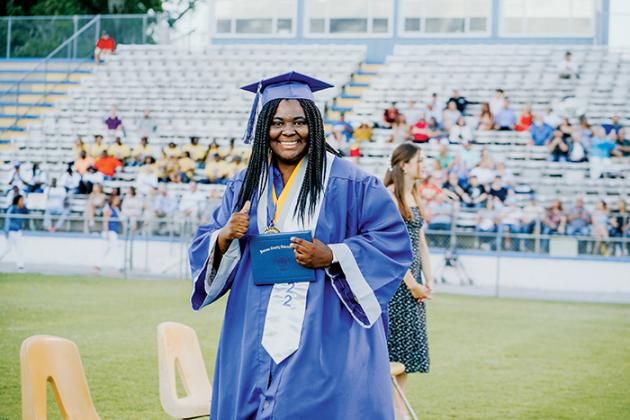 A Q.I. Roberts Junior-Senior High School graduate flashes the thumbs up sign after receiving her diploma during Saturday’s commencement ceremony in Palatka.