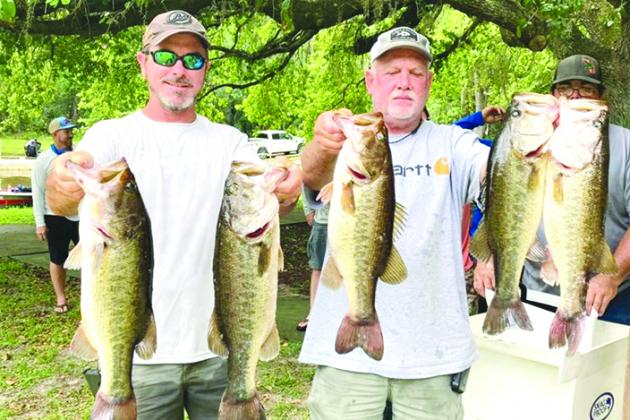 Brett Bollinger and Justin Atkinson hold up their winning fish at Rodman Reservoir’s Kenwood Landing at the NCF bass tournament Saturday. (GREG WALKER / Daily News Correspondent)