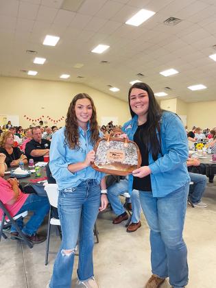 Youth Advisory Committee director Mackenzie Carle, right, presents a purse to Allison Tillis during the 2022 Livestock Awards on Monday.