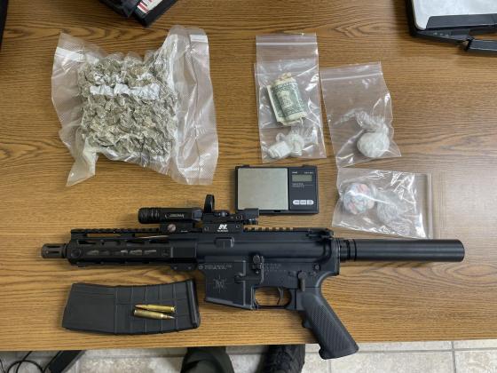 A semi-automatic rifle and seized drugs from a northside traffic stop Tuesday sit on a table.