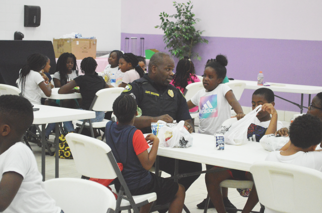 Capt. Tobby Williams has lunch with campers at Camp Higher Ground Monday morning. The camp is one of the Palatka Police Department's biggest community outreach programs.