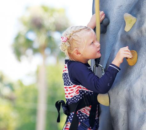 Danni Joy Kemper, 5, scales the rock climbing wall in downtown Interlachen on Monday afternoon during the town’s July 4 festivities.