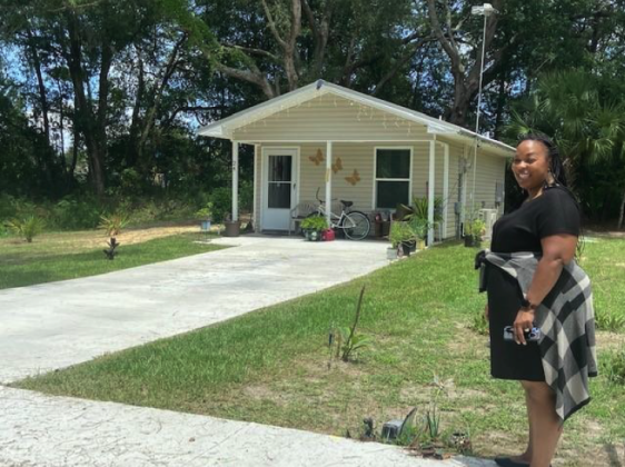 City Planner Sunshine Nealy stands in front of a 512-square-foot house recently.