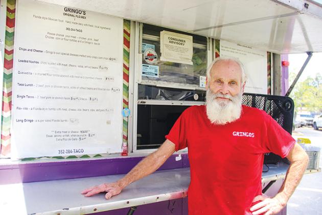Greg Cumbo, owner of Tacos Gringos, stands in front of his purple food truck Monday while parked at the Putnam County Courthouse.