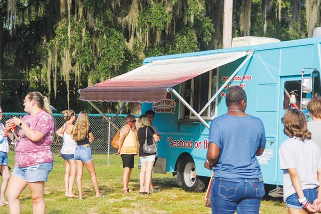 People line up in front of Country Girls Seafood Shack to order during Food Truck Friday in Welaka.