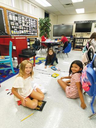 Elementary school students start their first day back to school with a smile.