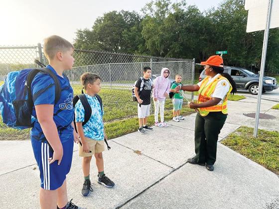 Students in Palatka wait for the signal from the crossing guard to walk across the street Wednesday during the first day of school. 
