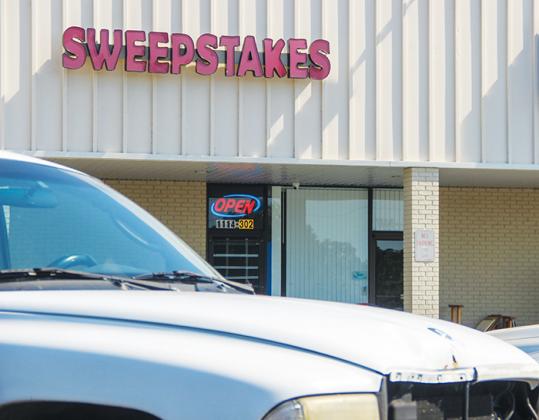 The Sweepstakes Internet Cafe in Interlachen has its windows blacked out as the open sign flashes early Tuesday morning after the Interlachen Town Council approved ousting simulated gambling devices.