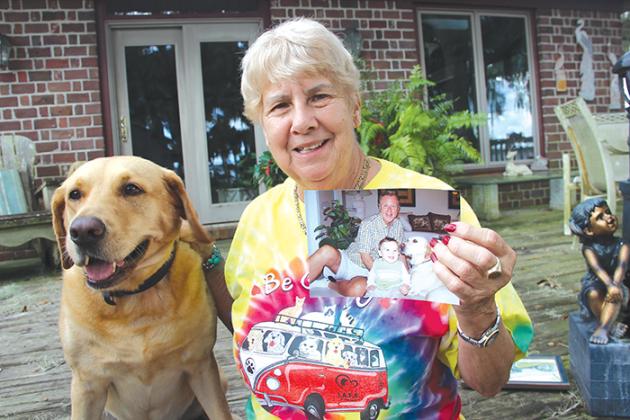 Carole Mussoline with her dog, Luna, holds a picture of her late brother, Tom Drusa, who died in April and left her $50,000. Drusa is pictured with his dog, River.