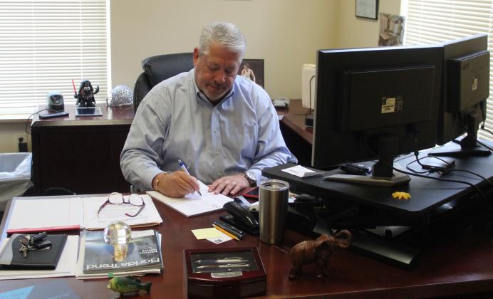 Mark Litten, the new vice president of economic development for the Putnam County Chamber of Commerce, examines paperwork at his desk Monday morning.