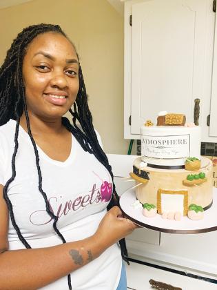 Brittani Wellon, owner of Sweets by Brittani LLC, holds the in-progress version of a  cake she worked on for Palatka-based Atmosphere Boutique and Spa’s second anniversary.