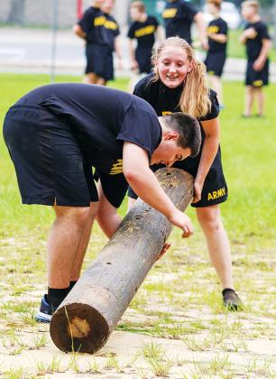 Cadet Summer Chase works to complete a set of log flips with the help of one of her fellow cadets. 