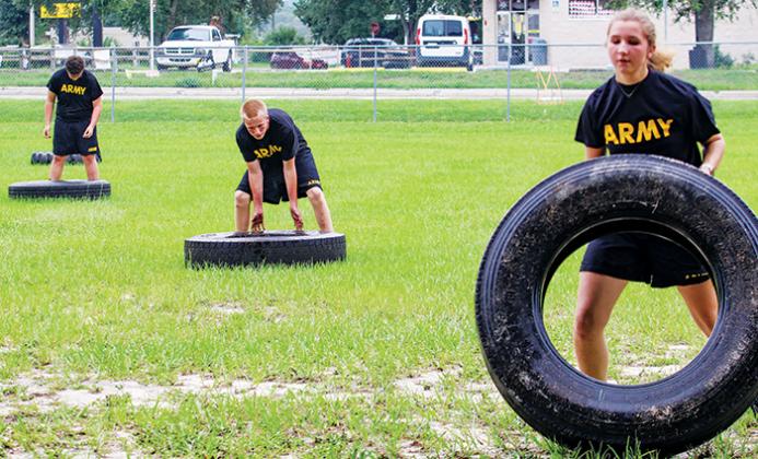 Cadets flip tires in a series of training exercises meant to prepare them for competition season.