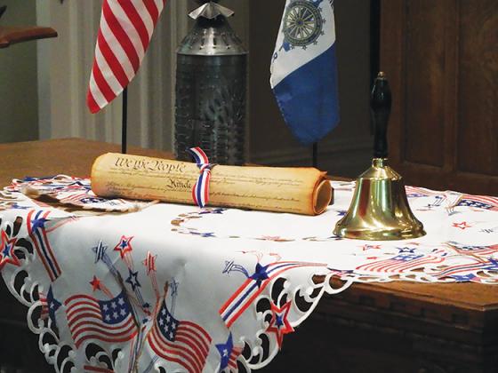 A patriotic display at the front of First Presbyterian Church of Palatka displays a reprint of the U.S. Constitution and a bell.