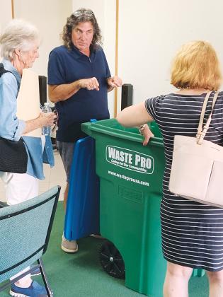 From left, Pat Mangan, Scott King and Crescent City Commissioner Lisa Devitto examine a 96-gallon WastePro trash bin at Crescent City’s City Hall.