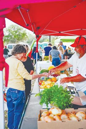 A woman purchases produce from a vendor at a recent Crescent City Art & Farmers Market.