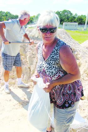 Jack and Cindy White fill bags of sand Monday afternoon to take to their Dunns Creek home in preparation for Hurricane Ian.