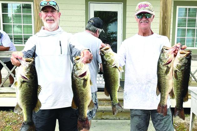 Frank Streeter, left, and Robin Hodges hold up their winning fish from the Messer’s Bait and Tackle qualifying Bass Tournament last Saturday. (GREG WALKER / Daily News correspondent)
