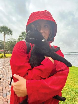 Jessica Fricker holds her cat, Choppy, who tried to escape on the Palatka riverfront after they rowed to shore Wednesday from their sailboat on the St. Johns River.