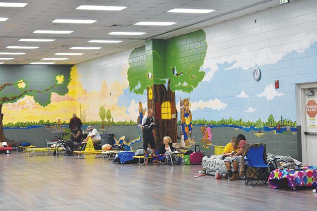 Shelter occupants at Browning-Pearce Elementary School converse with each other Thursday afternoon as rain and wind continued to swirl outside.