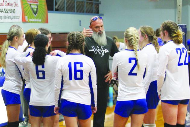 Peniel Baptist Academy volleyball coach Grady Wallace talks with his team during a first-set timeout Tuesday night. (MARK BLUMENTHAL / Palatka Daily News)