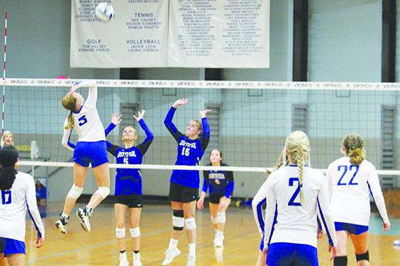 Peniel Baptist Academy’s Alexis Wallace goes high for a kill attempt against Countryside Christian’s Adysan Keith (5) and Delaney Robertson. (MARK BLUMENTHAL / Palatka Daily News)