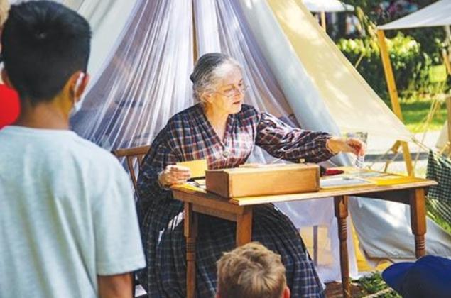 Historical reenactor Jean Dominguez teaches students about communications during the 1800s. (Palatka Daily News file)