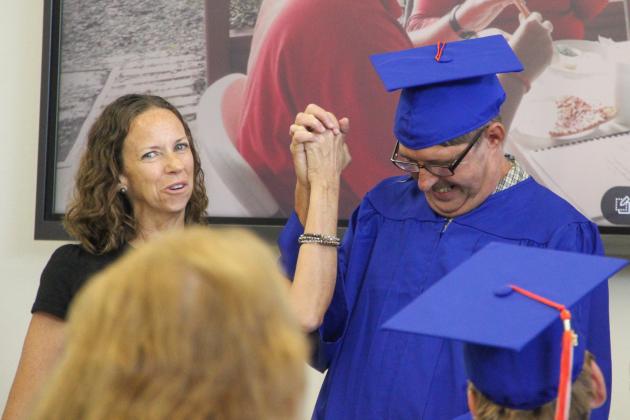 Photos by Sarah Cavacini/Palatka Daily News. Arc skills trainer Patty Dame holds Project SEARCH graduate Frank Koehler's hand in a triumphant grip as they both celebrate Koehler's graduation from a nine-month internship program at Beck Automotive Group. 