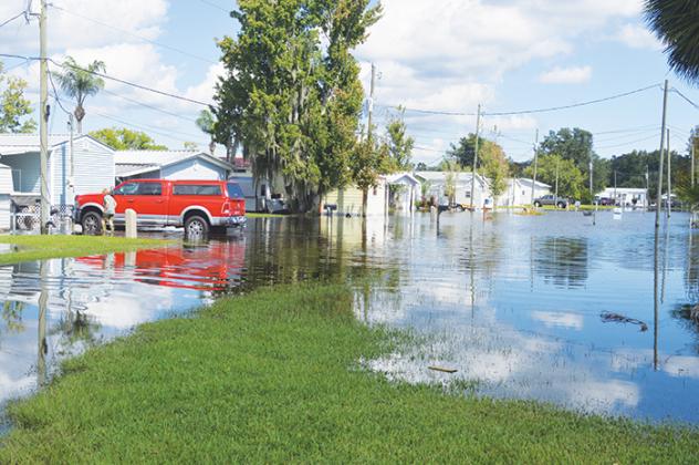 While floodwaters had receded quite a bit, residents of Sportsman’s Harbor in Welaka still had to wade through water to get into their homes on Monday.