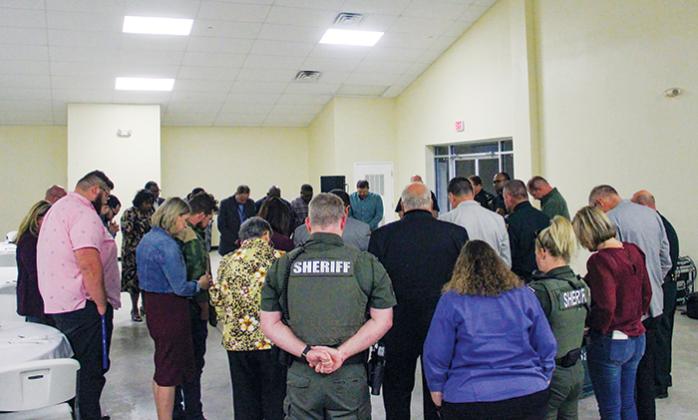 Pastors and law enforcement officers join together in a final prayer at the end of the Faith & Blue Pastoral Appreciation Dinner on Monday.