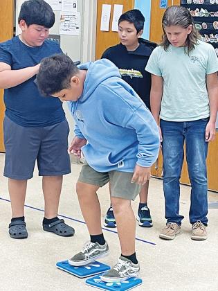 A sixth grader stomps on an Unruly Splats pad during a STEM program.