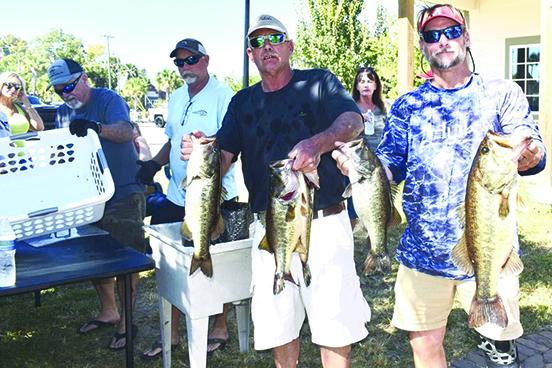 Rusty Fox, center, and Kevin Falls hold up their  winning fish at Saturday’s Messer’s Invitational. (GREG WALKER / Daily News correspondent)