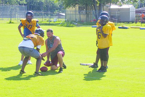 Crescent City athletic director and middle school football coach Tim Ross works with quarterbacks and running backs during an August practice. (MARK BLUMENTHAL / Palatka Daily News)
