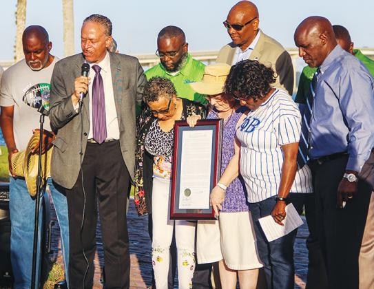 Previous and current city officials gather in prayer Saturday at the Palatka riverfront after the riverfront marina was named in honor of former City Commissioner Mary Lawson Brown, center.