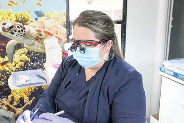 Dental hygienist Lindsey Stein cleans a patient’s teeth in Interlachen on Monday.