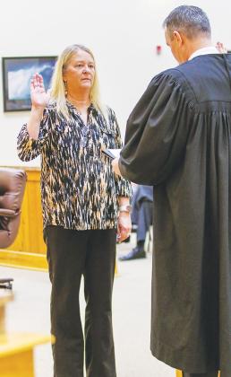 School board member Linda Wagner raises her right hand and takes her oath of office during the swearing-in ceremony.