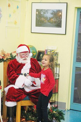 Alyson Valdes, 6, is excited to meet Santa Claus at Lemon Street Market & Mercantile after the Christmas parade.