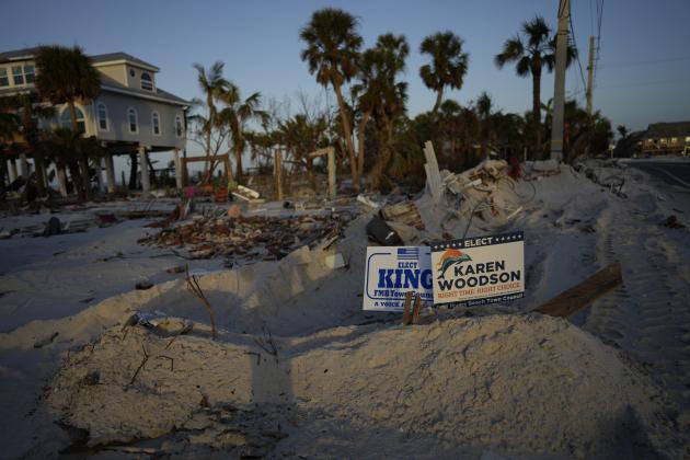 Signs promoting candidates for Fort Myers Beach town council sit along a roadside on Estero Island, which was heavily damaged in September's Hurricane Ian, in Fort Myers Beach, Fla, Tuesday, Nov. 8, 2022. After the area was devastated and thousands were left displaced by Hurricane Ian, Lee County extended their early voting period and permitted voters on Election Day to cast their ballot in any of the dozen open polling places. (AP Photo/Rebecca Blackwell)