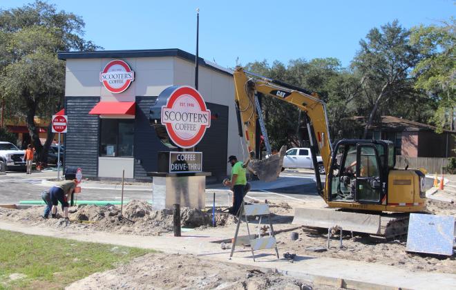 Construction workers work to finish a Scooter's Coffee on State Road 19 that is expected to open in a few weeks.