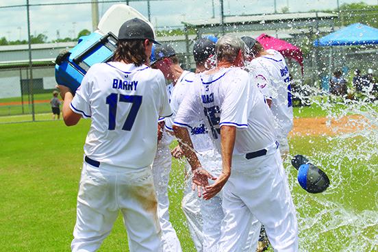 Melrose 15-and-under first baseman Gauge Barry douses head coach Dale Yarbrough after a 15-3 victory over West Volusia-Debary in the North Florida 15-U Babe Ruth All-Star baseball championship on July 17 in Lake City. (MARK BLUMENTHAL / Palatka Daily News)