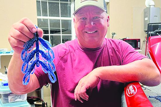 Pro angler Terry Scroggins displays some new soft craw baits he’s designed at his home shop. (GREG WALKER / Daily News correspondent)