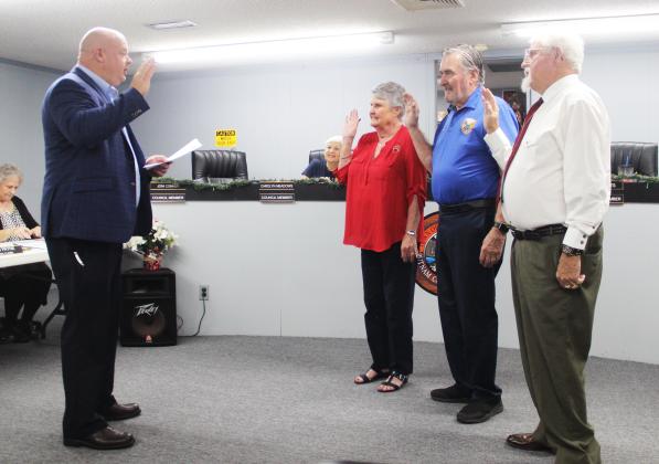 Interlachen Town Attorney George Young on Tuesday swears in, from left to right, Town Council Member Joni Conner, Mayor Ken Larsen and newly elected Town Council Member David Yonts.