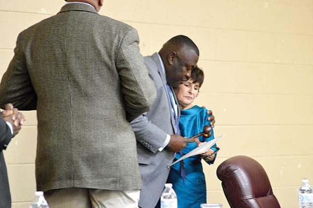 Outgoing Mayor Terrill Hill hugs incoming Mayor Robbi Correa and hands her the gavel during a swearing-in ceremony Monday at the Price-Martin Community Center.
