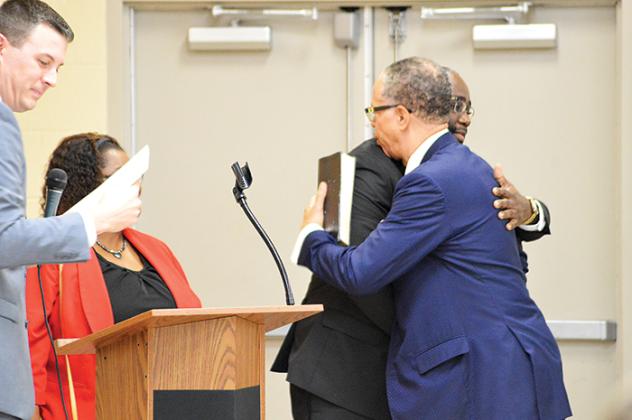 Commissioner Justin Campbell, left, hugs former Palatka Mayor Karl Flagg on Monday during the swearing-in ceremony.
