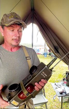 World War II reenactor Thomas Philyaw holds a handheld field phone first used in WWII by paratroopers and infantry.
