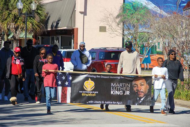 People honor the Rev. Martin Luther King Jr. on Monday by participating in a legacy walk along St. Johns Avenue in Palatka.