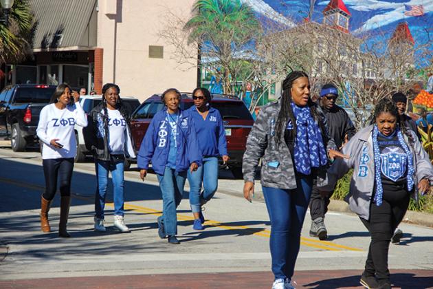 Members of Zeta Phi Beta Sorority Inc. walk down St. Johns Avenue for Martin Luther King Jr. Day on Monday.