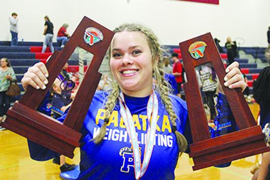  Palatka’s Camden Posey, the district champion at 169 pounds, shows off her team’s two big championship trophies. (COREY DAVIS / Palatka Daily News)