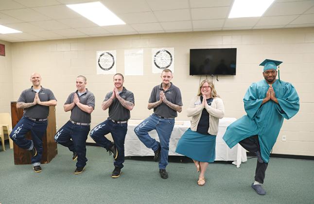 Kimberly Simon, second from right, director of programs for Yoga 4 Change’s northeast Florida region, leads Insight participants in the tree pose during a ceremony last week where Insight members were honored.
