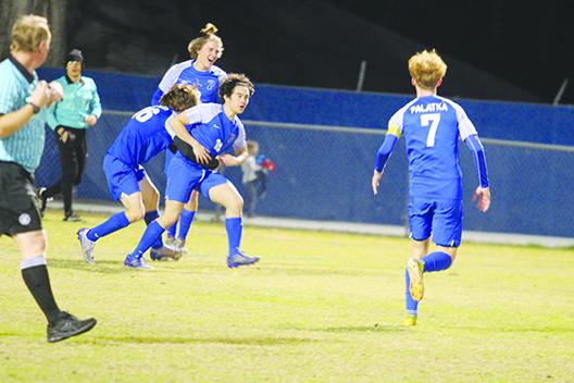 Palatka’s Noah Lotow is hugged by teammate Devin Walker, while teammates Braxton Anderson and Justin Foreman join in after Lotow’s first-half goal against Baker County in the District 2-4A Tournament opening round.  (MARK BLUMENTHAL / Palatka Daily News)